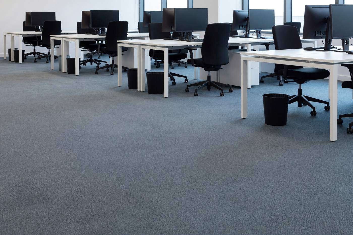 The same office after cleaning, carpet tiles even and desks clear